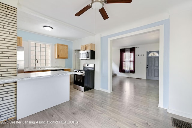 kitchen with a sink, stainless steel appliances, light wood-type flooring, visible vents, and a ceiling fan