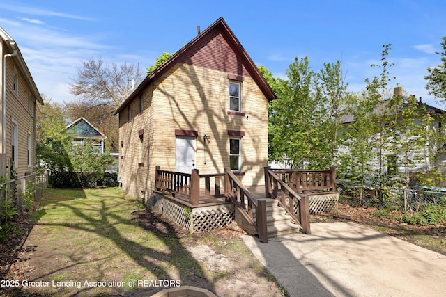 back of house featuring a fenced backyard, a deck, and a yard