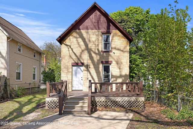 back of house featuring fence and a wooden deck