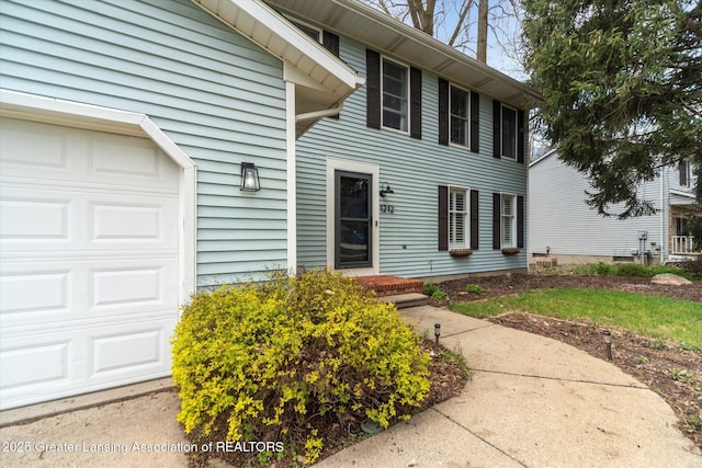 1212 Sandhill Dr, Dewitt, MI 48820 - view of exterior entry featuring a garage