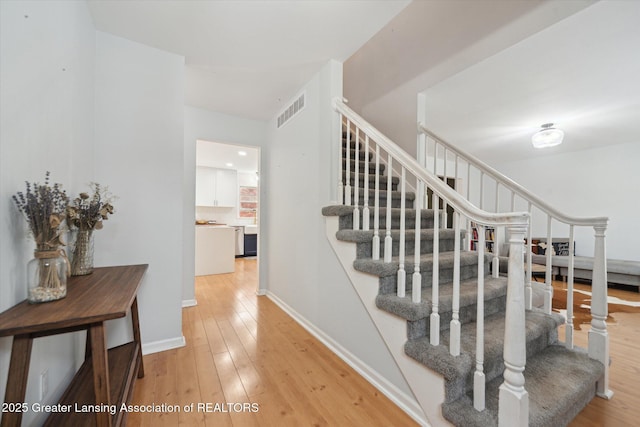 1212 Sandhill Dr, Dewitt, MI 48820 - staircase featuring baseboards, visible vents, and wood-type flooring