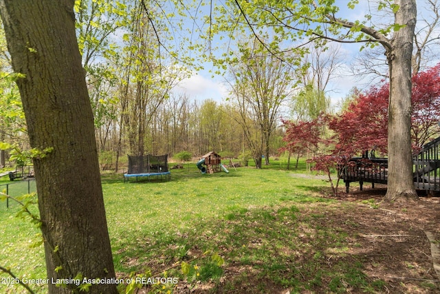 1212 Sandhill Dr, Dewitt, MI 48820 - view of yard with a playground, a trampoline, and a deck