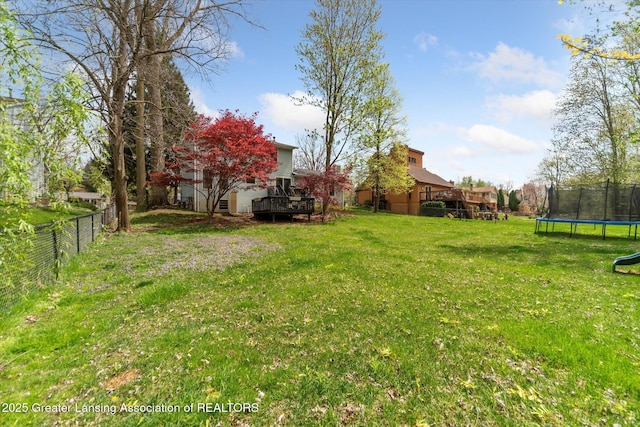 1212 Sandhill Dr, Dewitt, MI 48820 - view of yard with fence, a trampoline, and a deck