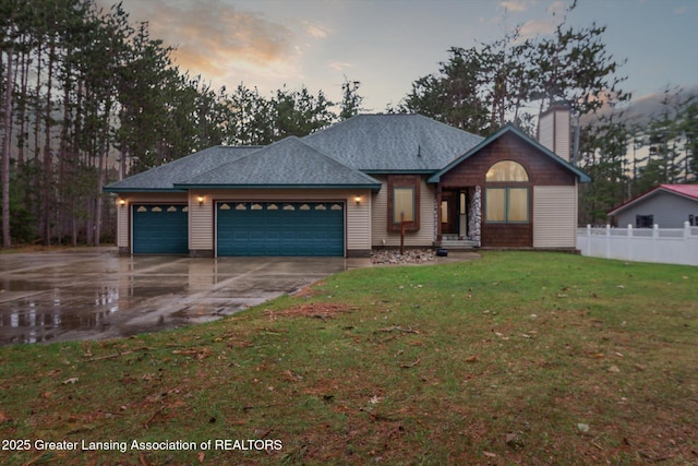 ranch-style house featuring fence, an attached garage, a front lawn, a chimney, and driveway