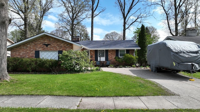 ranch-style home with concrete driveway, brick siding, a chimney, and a front yard
