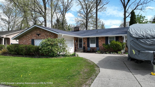 single story home featuring an attached garage, a chimney, concrete driveway, a front yard, and brick siding