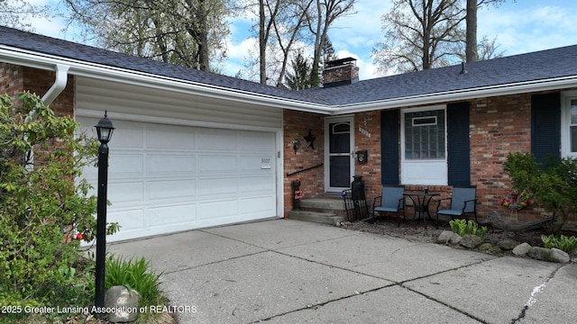 single story home with a chimney, driveway, brick siding, a garage, and roof with shingles