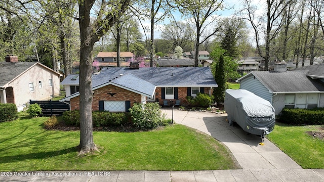 ranch-style house with driveway, a residential view, brick siding, and a front yard