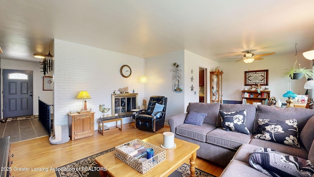 living room with wood finished floors, a fireplace, and ceiling fan