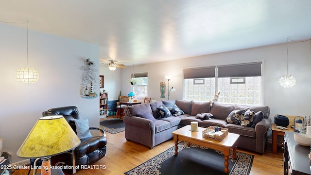 living room with a ceiling fan and light wood-type flooring