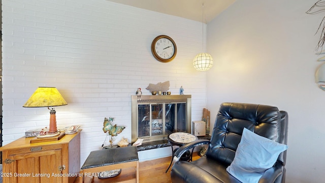 living room with a fireplace, lofted ceiling, and wood finished floors