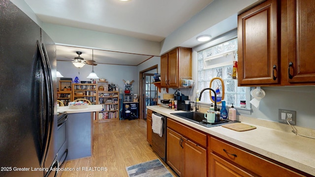 kitchen featuring a ceiling fan, light wood finished floors, a sink, black appliances, and light countertops