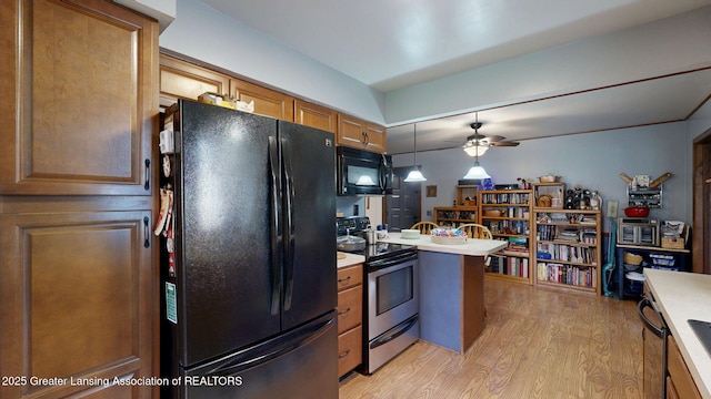 kitchen with a ceiling fan, black appliances, light countertops, and light wood finished floors