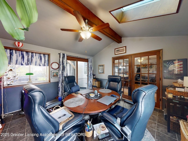 tiled dining area with ceiling fan and lofted ceiling with skylight