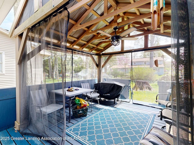 sunroom / solarium with a healthy amount of sunlight, outdoor dining area, and ceiling fan