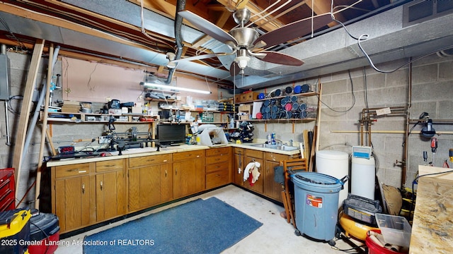 unfinished basement with ceiling fan, visible vents, and concrete block wall