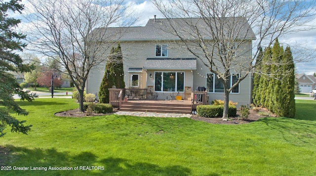 rear view of house featuring a lawn, roof with shingles, and a wooden deck