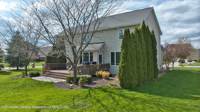 rear view of house featuring a lawn and a deck