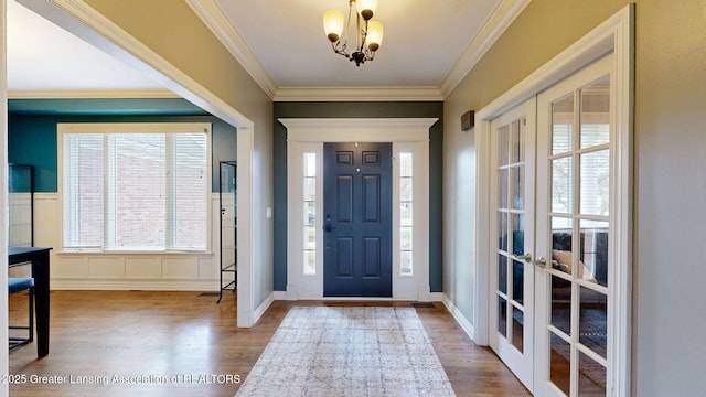 foyer entrance featuring a wealth of natural light, wood finished floors, and french doors