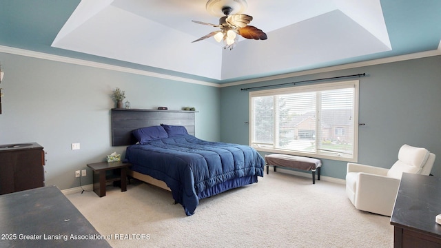 bedroom featuring a ceiling fan, baseboards, a raised ceiling, light colored carpet, and ornamental molding