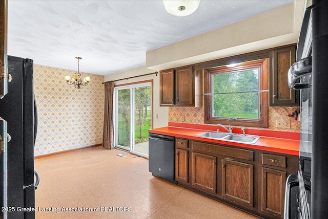 kitchen with wallpapered walls, decorative light fixtures, a sink, a chandelier, and black appliances