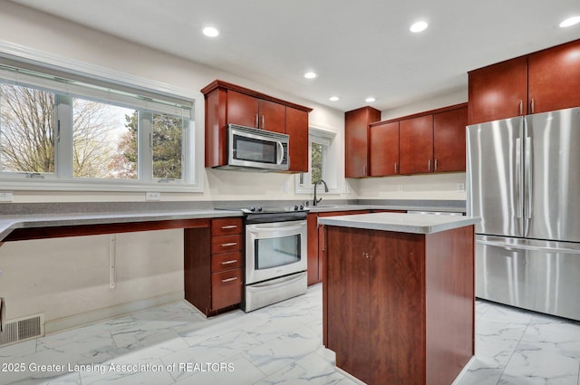 kitchen with stainless steel appliances, marble finish floor, visible vents, recessed lighting, and reddish brown cabinets
