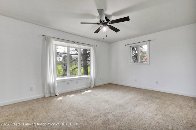 empty room featuring carpet, visible vents, baseboards, and a ceiling fan