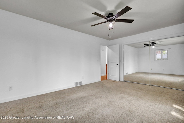 unfurnished bedroom featuring baseboards, ceiling fan, visible vents, and carpet