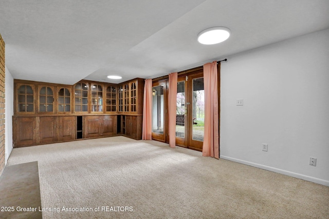 unfurnished room with light colored carpet and baseboards