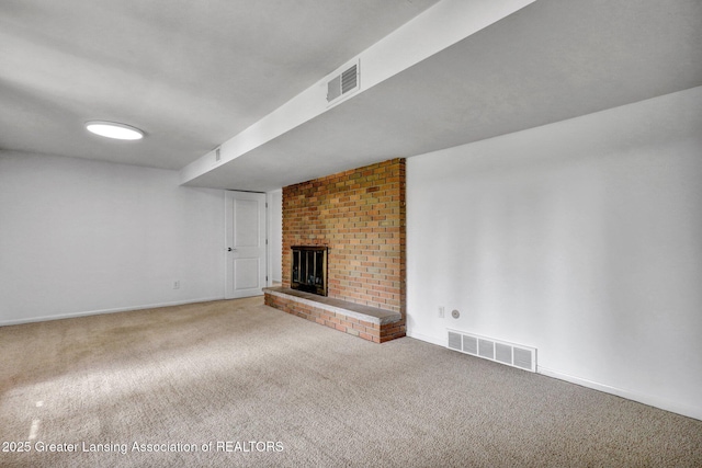 unfurnished living room featuring carpet flooring, visible vents, and a fireplace