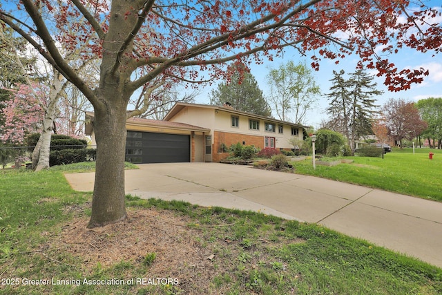view of front of property with brick siding, fence, a garage, concrete driveway, and a front yard