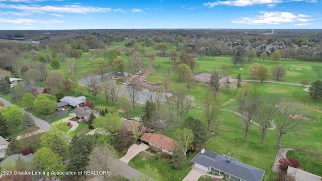 drone / aerial view featuring a water view, golf course view, and a residential view