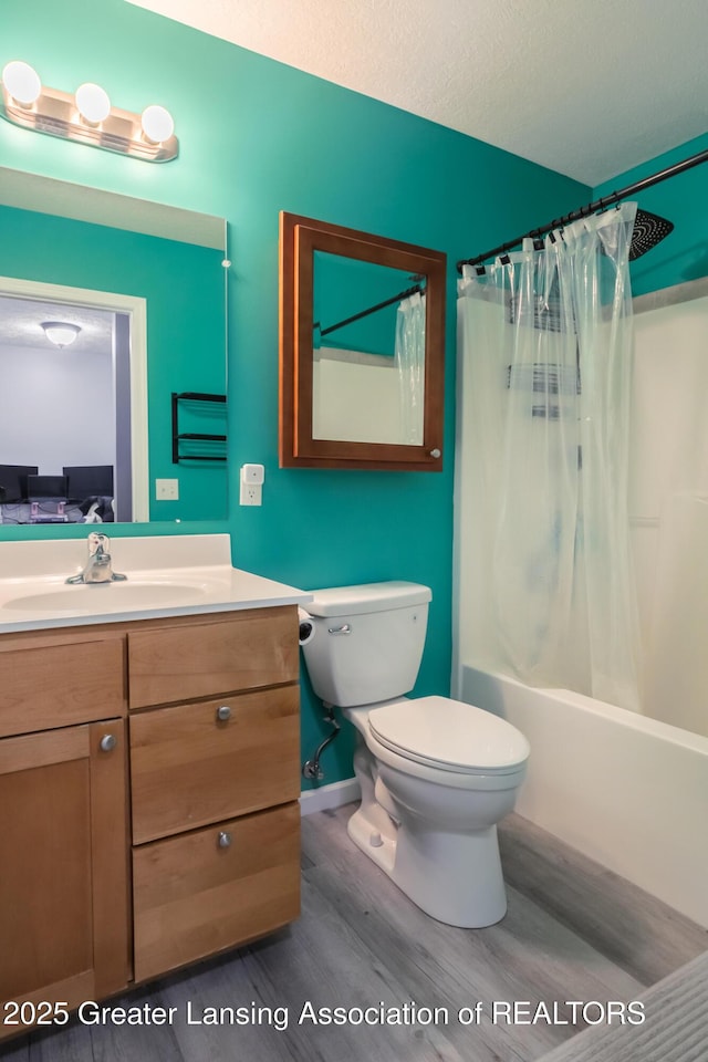 13799 Mead Creek Rd Unit 63D, Bath, MI 48808 - full bathroom with wood finished floors, toilet, vanity, shower / bath combination with curtain, and baseboards