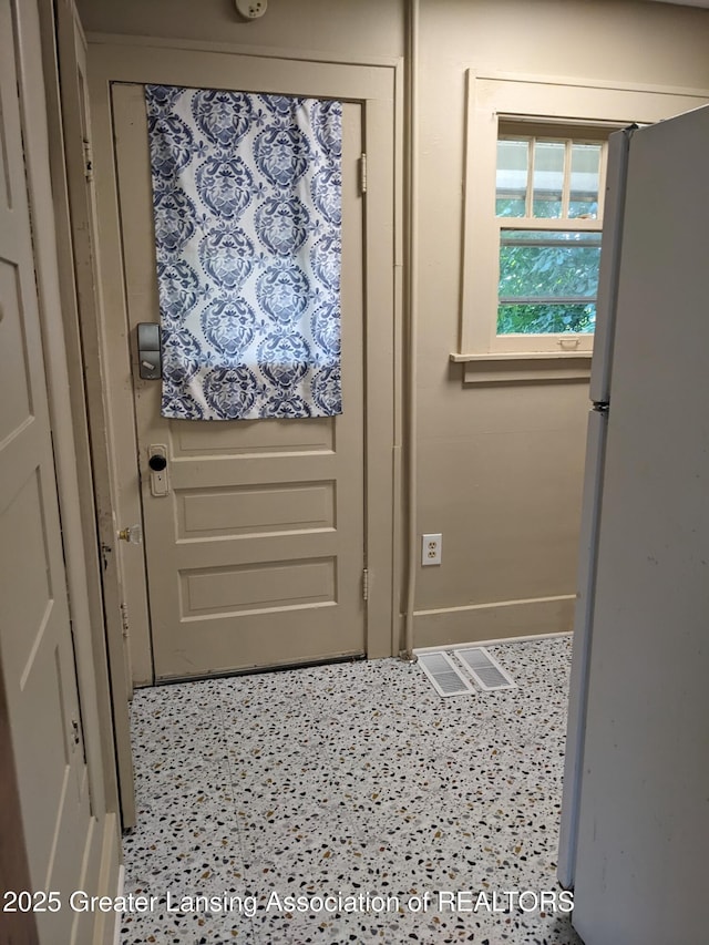 doorway featuring baseboards and visible vents