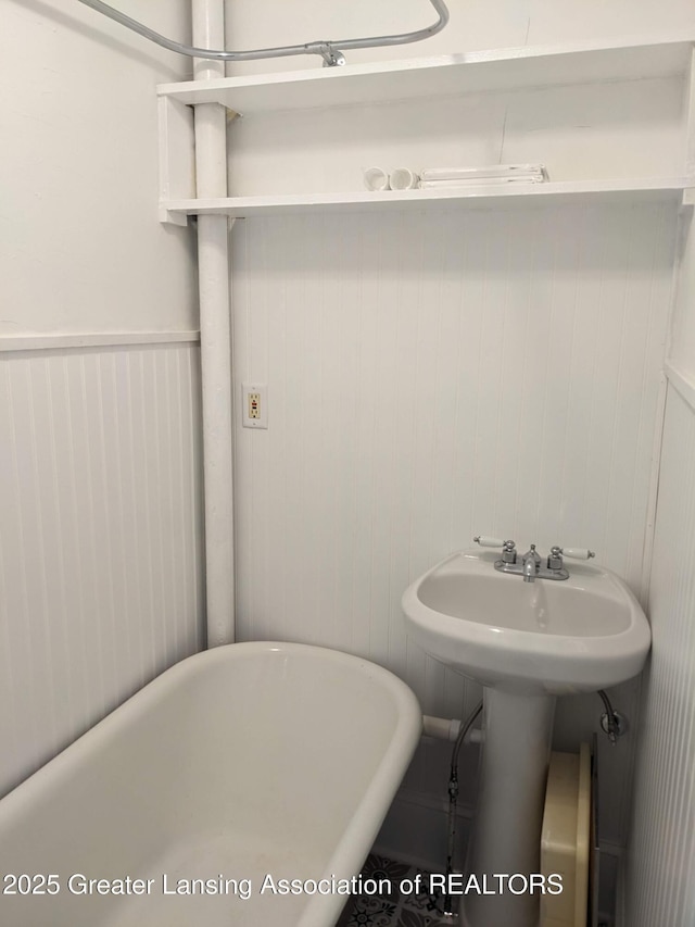 bathroom featuring wainscoting and a freestanding bath