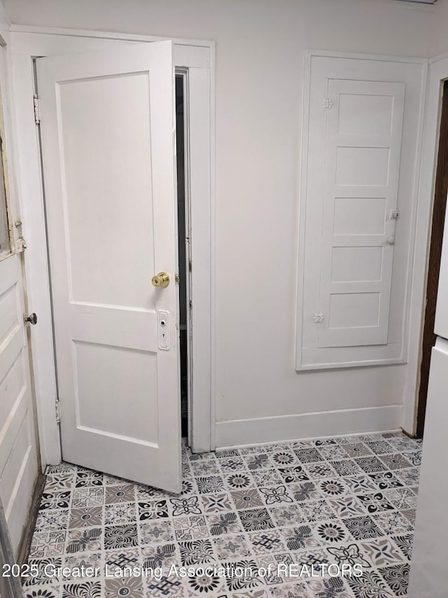 interior space featuring light tile patterned flooring and baseboards