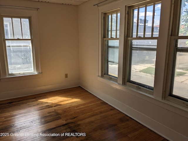 empty room featuring dark wood-type flooring and baseboards