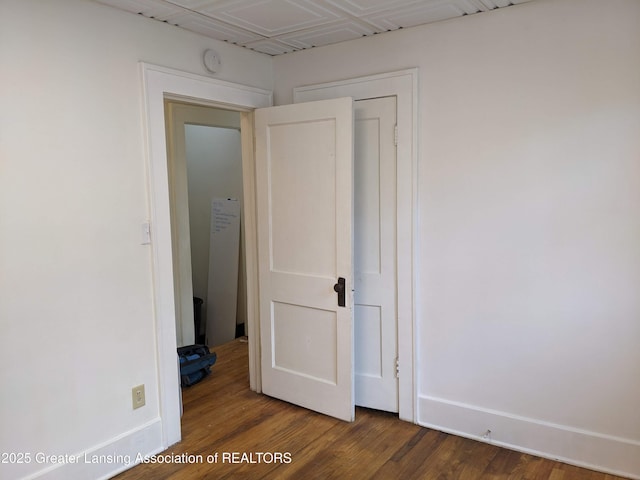 unfurnished bedroom featuring baseboards and wood finished floors