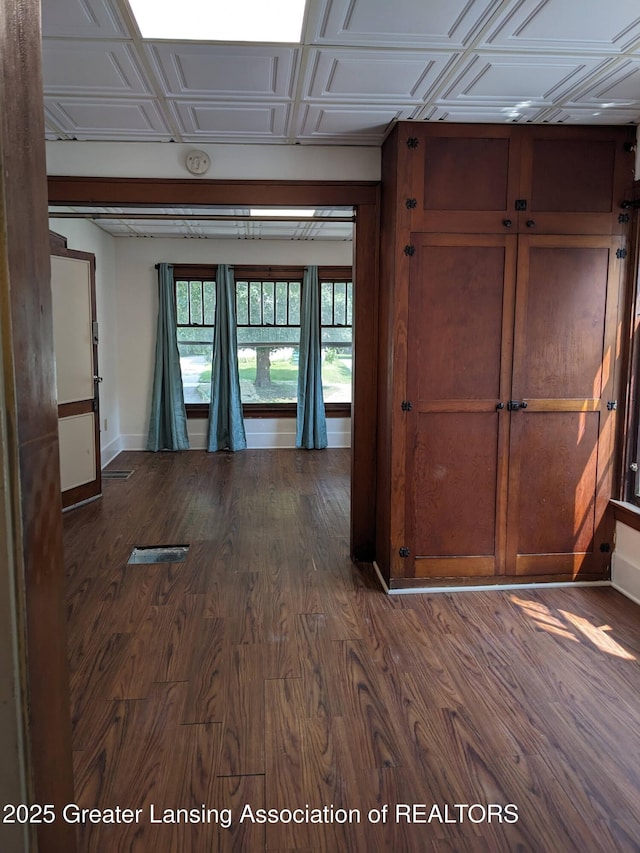 empty room featuring baseboards and dark wood-style floors