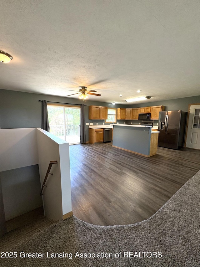 5205 N Bailey Rd, Coral, MI 49322 - kitchen featuring stainless steel appliances, a center island, brown cabinetry, light countertops, and recessed lighting