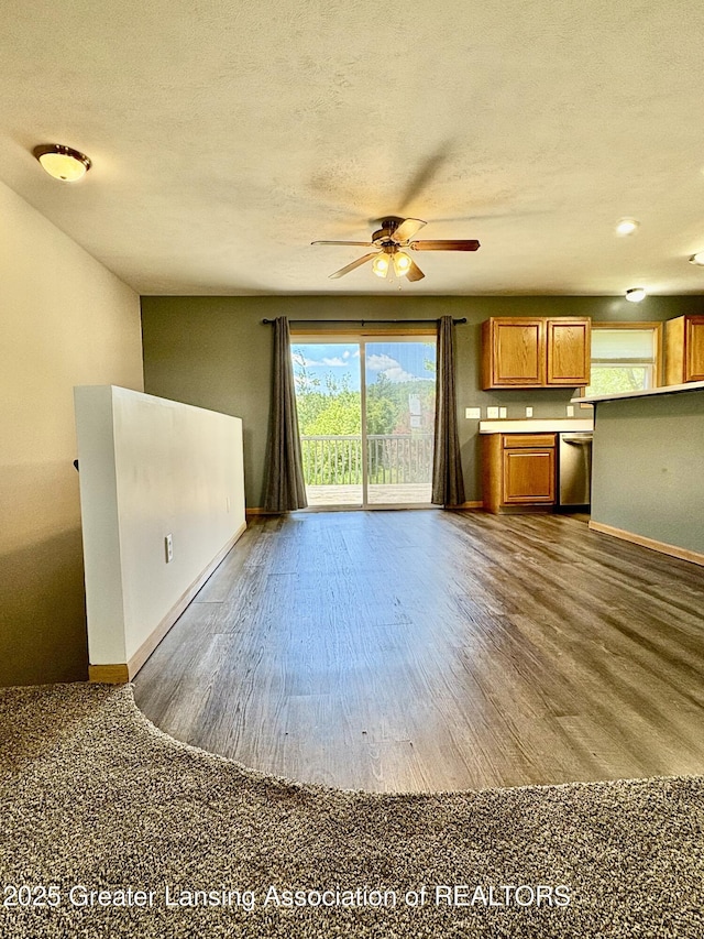 5205 N Bailey Rd, Coral, MI 49322 - unfurnished living room featuring ceiling fan, dark wood-style flooring, and a textured ceiling