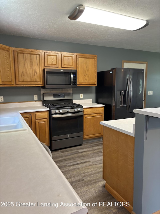 5205 N Bailey Rd, Coral, MI 49322 - kitchen with stainless steel gas stove, fridge with ice dispenser, light countertops, dark wood finished floors, and a textured ceiling