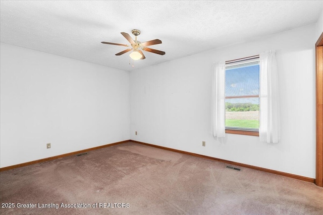 unfurnished room with baseboards, ceiling fan, visible vents, and carpet