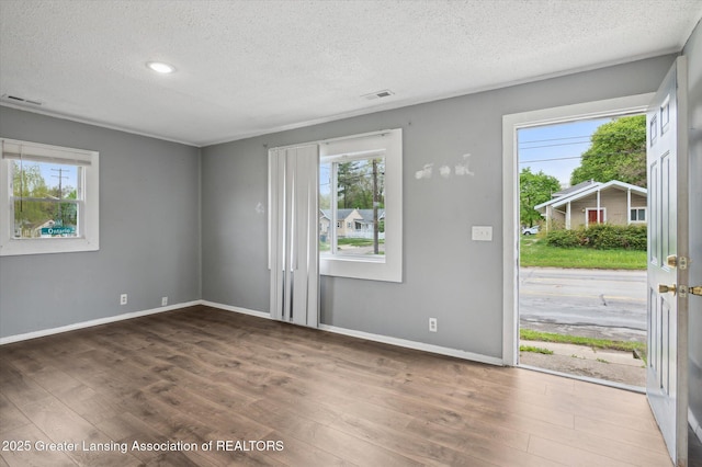 1406 N Martin Luther King Jr Blvd, Lansing, MI 48915 - interior space featuring a textured ceiling, visible vents, a healthy amount of sunlight, and wood finished floors