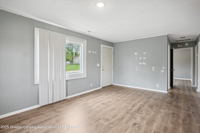 1406 N Martin Luther King Jr Blvd, Lansing, MI 48915 - unfurnished living room with a textured ceiling, visible vents, wood finished floors, and baseboards