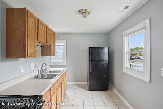 1406 N Martin Luther King Jr Blvd, Lansing, MI 48915 - kitchen with baseboards, visible vents, a sink, black appliances, and light countertops