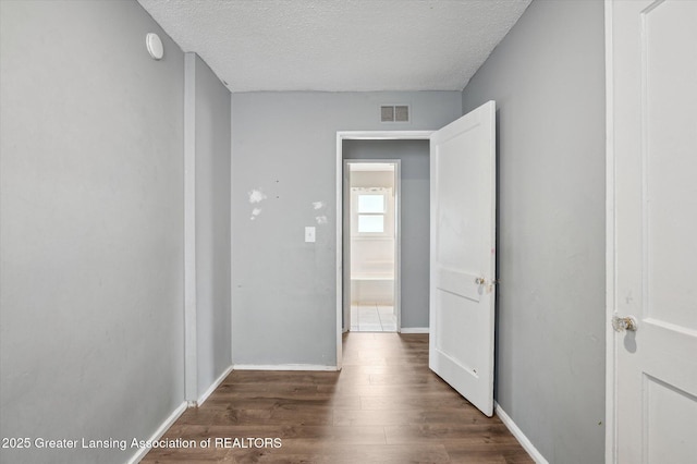1406 N Martin Luther King Jr Blvd, Lansing, MI 48915 - hall featuring baseboards, visible vents, a textured ceiling, and wood finished floors