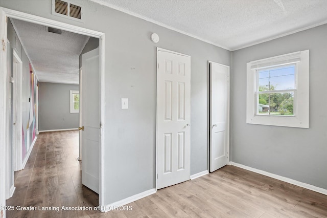 1406 N Martin Luther King Jr Blvd, Lansing, MI 48915 - unfurnished bedroom featuring a textured ceiling, visible vents, and wood finished floors