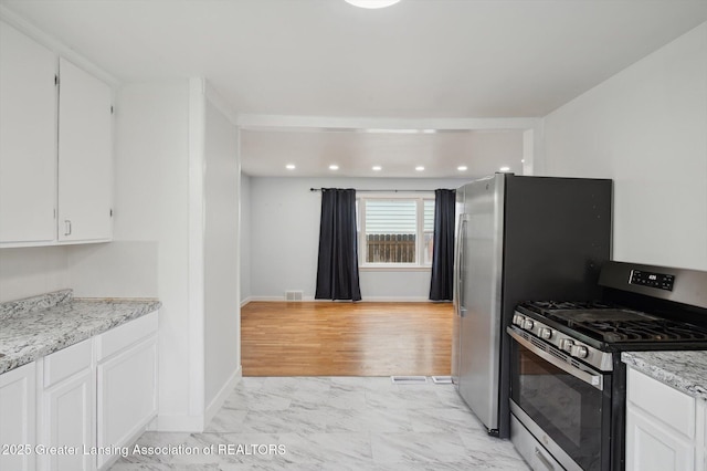 900 Holten St, Lansing, MI 48915 - kitchen featuring stainless steel range with gas cooktop, light marble finish flooring, white cabinets, baseboards, and light stone counters