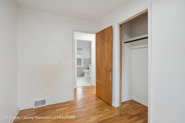 900 Holten St, Lansing, MI 48915 - unfurnished bedroom with light wood finished floors, a closet, and baseboards